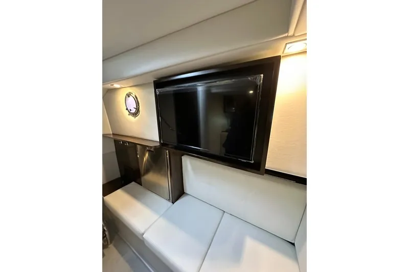 Slide: The Image of Interior of 2021 Cruisers Yachts 338 South Beach Edition, featuring a sleek TV and seating area. - 16