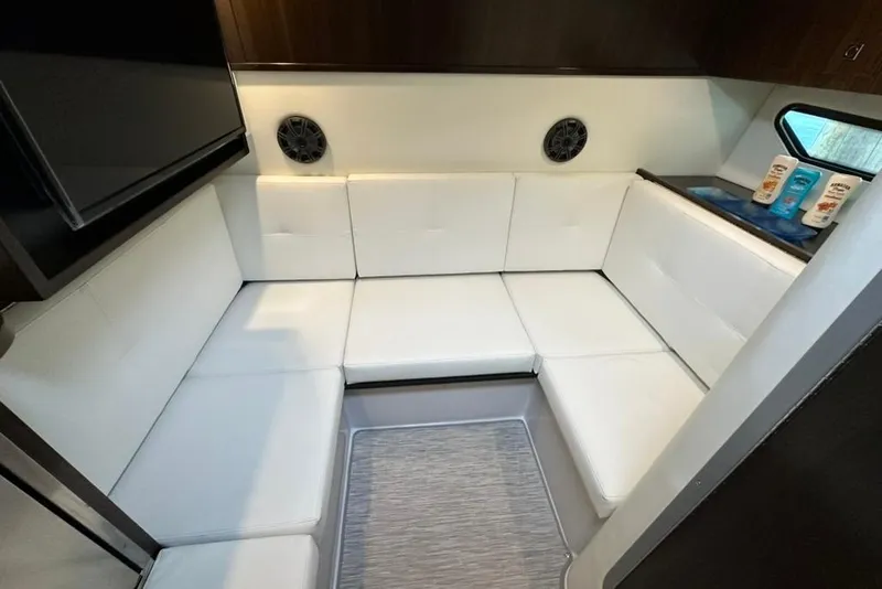 Slide: The Image of 2021 Cruisers Yachts 338 South Beach Edition Bow Rider interior with white seating and modern design. - 10
