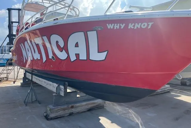 The Image of Red 2015 Comercial Water Sports Ocean Pro 31 boat on dry dock, named "Why Knot." - 0