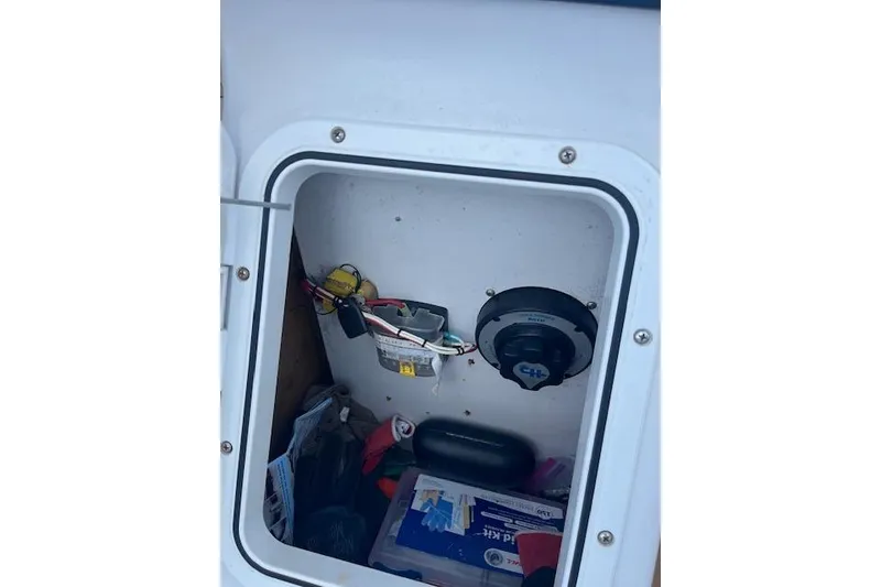 Slide: The Image of Storage compartment of 2015 Comercial Water Sports Ocean Pro 31 boat, showing equipment and supplies. - 25