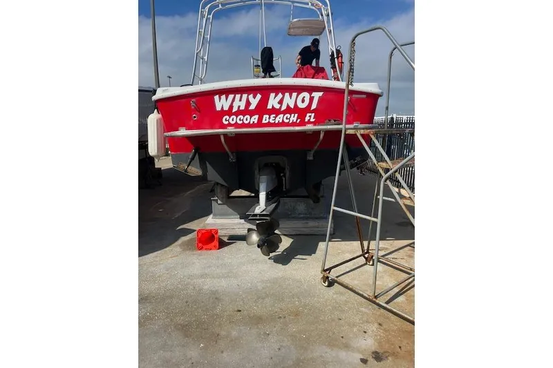 Slide: The Image of Red "Why Knot" boat, Cocoa Beach, FL, on dry dock; Comercial Water Sports Ocean Pro 31, 2015. - 3