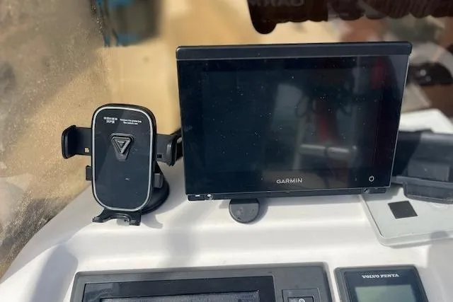 Slide: The Image of Garmin display and phone holder on 2015 Comercial Water Sports Ocean Pro 31 dashboard. - 8