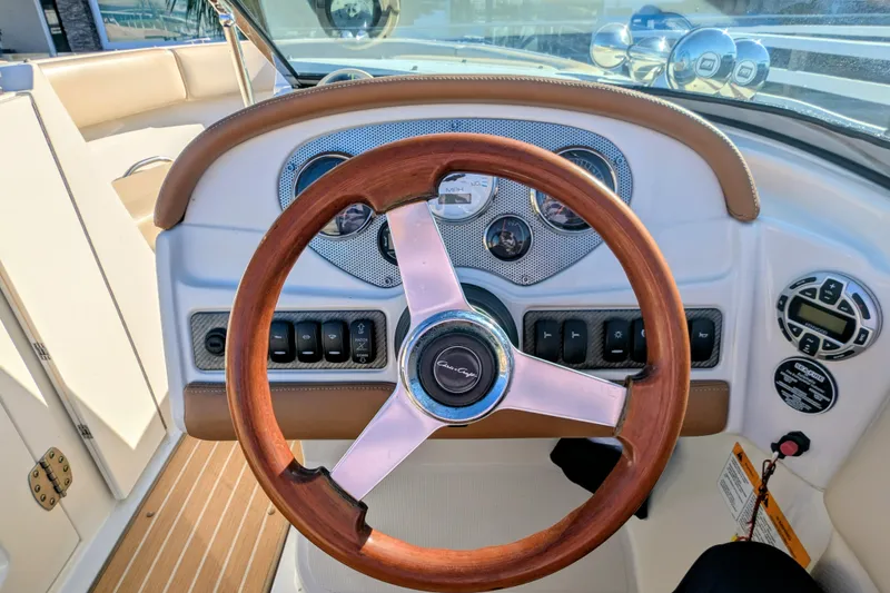 Slide: The Image of 2008 Chris-Craft Launch 25 dashboard with wooden steering wheel and control panel. - 17
