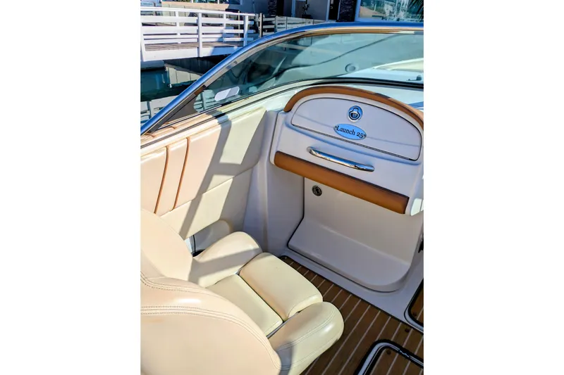 Slide: The Image of 2008 Chris-Craft Launch 25 boat interior with beige seating and wooden flooring. - 19