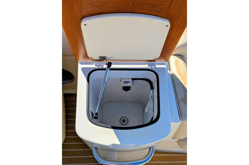 Slide: The Image of Open storage compartment on 2008 Chris-Craft Launch 25 boat, featuring wooden lid and hydraulic support. - 21