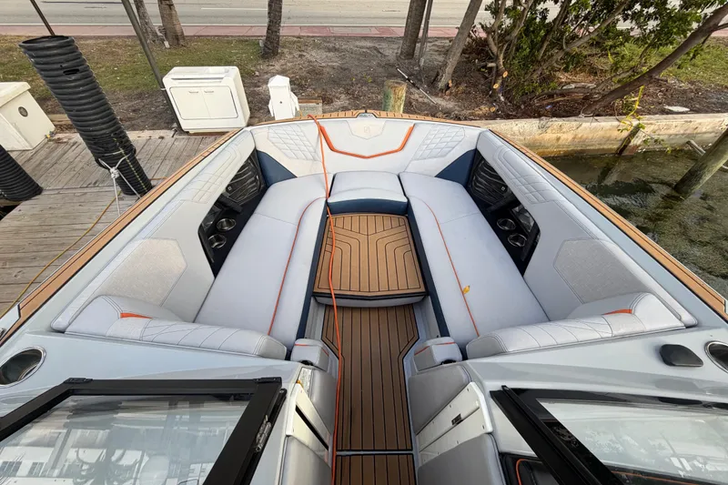 Slide: The Image of 2022 Nautique Super Air Nautique G25 boat interior with luxurious seating and teak flooring. - 14