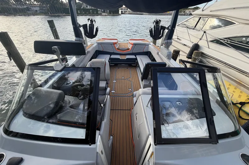 Slide: The Image of 2022 Nautique Super Air Nautique G25 boat interior with seating and steering wheel. - 17