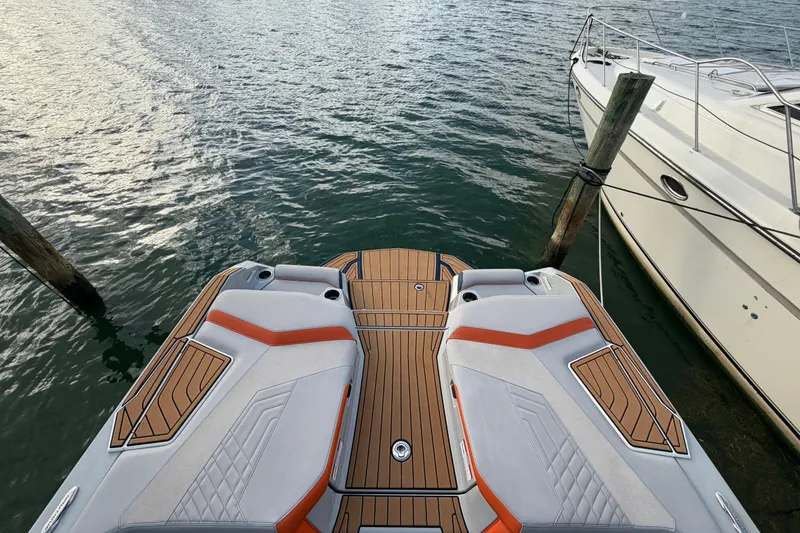 Slide: The Image of 2022 Nautique Super Air Nautique G25 boat docked on calm water. - 5