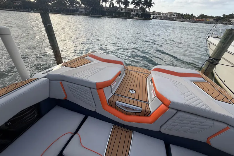 Slide: The Image of 2022 Nautique Super Air Nautique G25 boat interior with stylish seating and wood accents. - 7