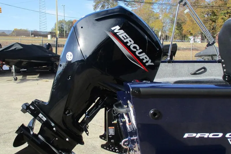 Slide: The Image of 2026 Tracker Pro Guide V-16 WT boat with Mercury outboard motor in a parking lot. - 4