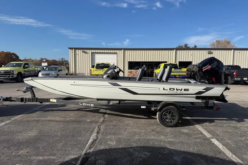 The Image of 2026 Lowe Outlet 20 boat on trailer in parking lot, sunny day. - 0