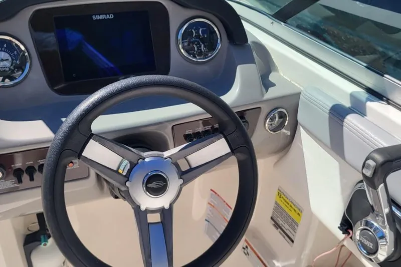 Slide: The Image of 2022 Chaparral 23 SSi boat dashboard with steering wheel and control panel. - 5