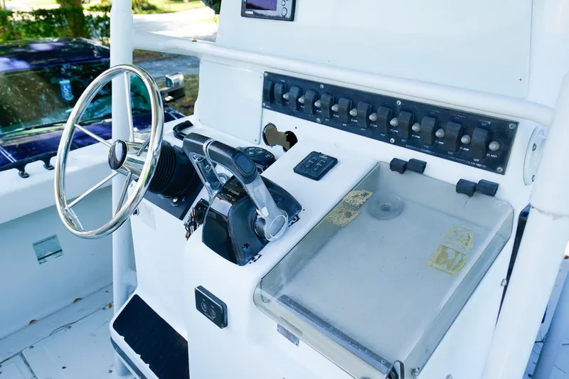Slide: The Image of Control panel of a 2005 Boston Whaler 260 Justice boat with steering wheel and switches. - 10