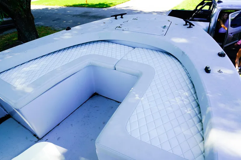 Slide: The Image of 2005 Boston Whaler 260 Justice boat with white cushioned seating and deck view. - 14