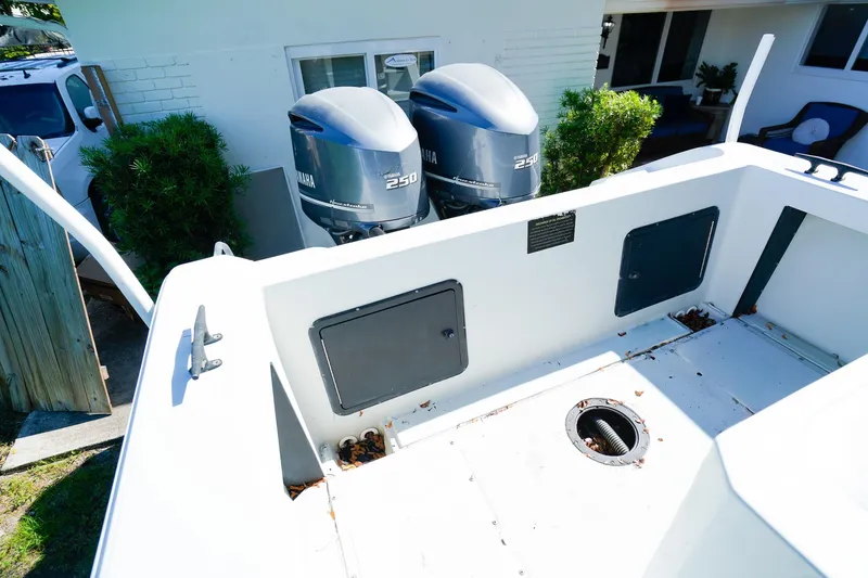 Slide: The Image of 2005 Boston Whaler 260 Justice boat with dual Yamaha 250 engines, docked near a house. - 3