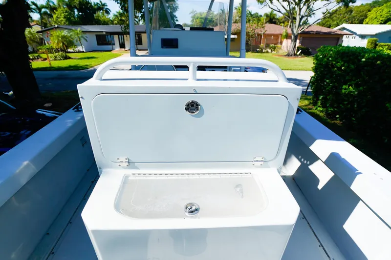 Slide: The Image of 2005 Boston Whaler 260 Justice boat interior with storage compartment, outdoor setting. - 5