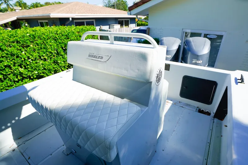 Slide: The Image of 2005 Boston Whaler 260 Justice boat with cushioned seating and dual engines. - 7