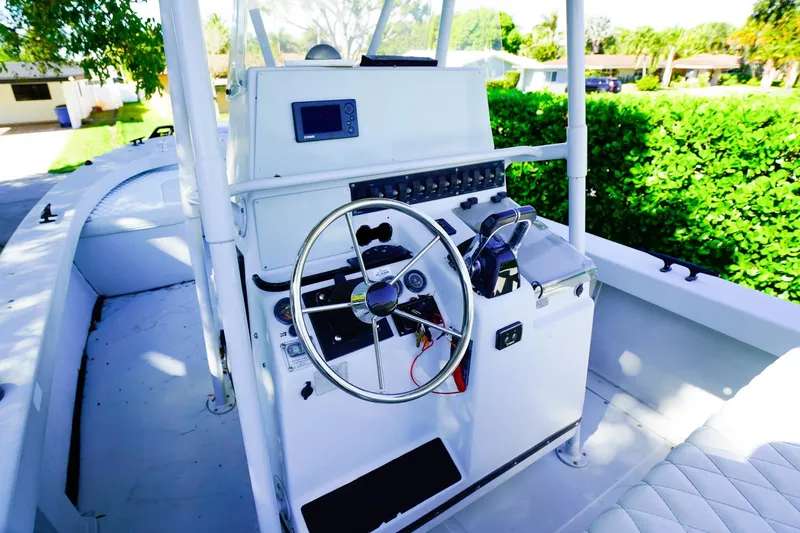 Slide: The Image of 2005 Boston Whaler 260 Justice boat cockpit with steering wheel and control panel. - 8