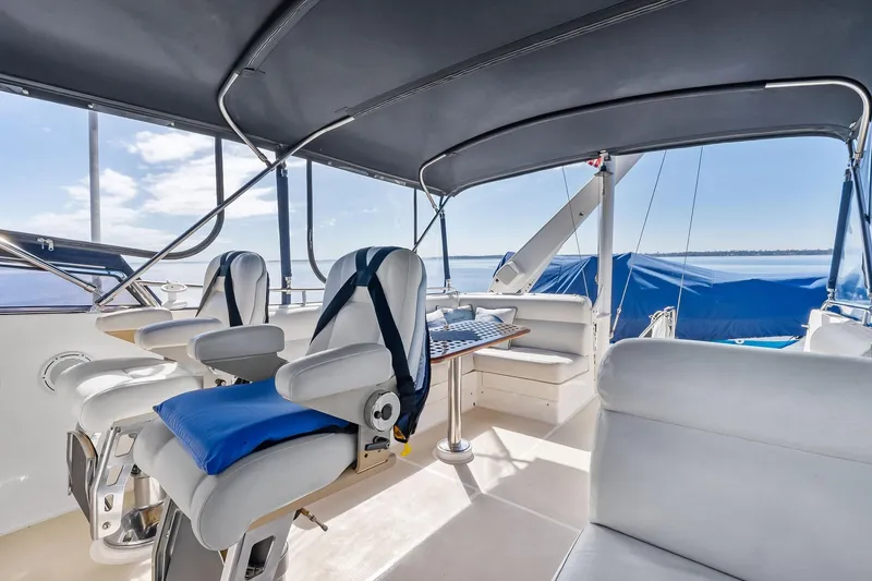 Slide: The Image of Flybridge of 2006 Grand Banks Europa 47 yacht with seating and table, under canopy. - 13