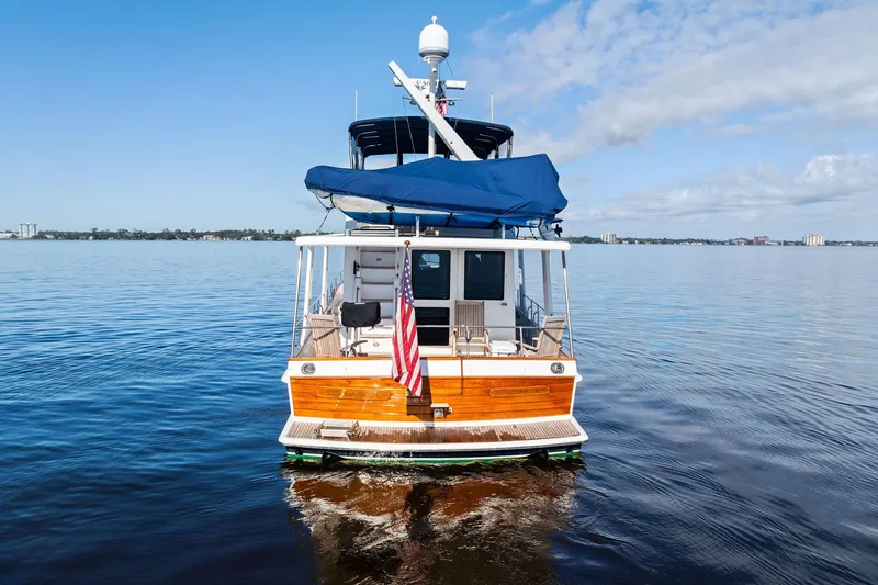 Slide: The Image of 2006 Grand Banks Europa 47 yacht on calm water, rear view with American flag. - 2