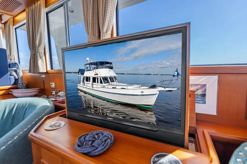 Slide: The Image of Interior of a 2006 Grand Banks Europa 47 yacht with a TV displaying the boat. - 26