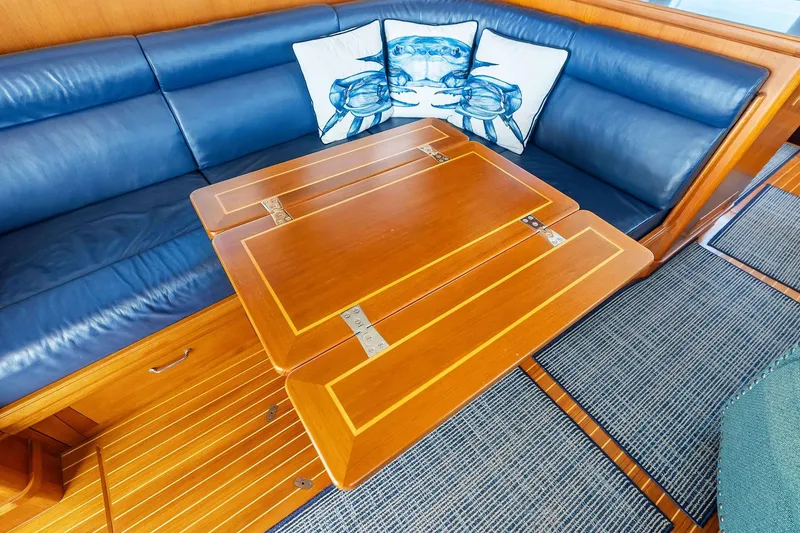 Slide: The Image of Interior of 2006 Grand Banks Europa 47 with blue seating and wooden table. - 28