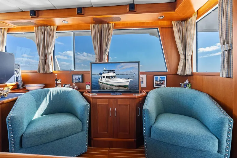 Slide: The Image of Luxurious 2006 Grand Banks Europa 47 yacht interior with blue armchairs and scenic window views. - 29