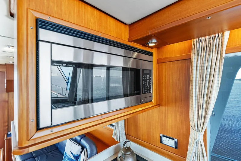 Slide: The Image of Microwave in 2006 Grand Banks Europa 47 yacht interior, featuring wood paneling and window view. - 36