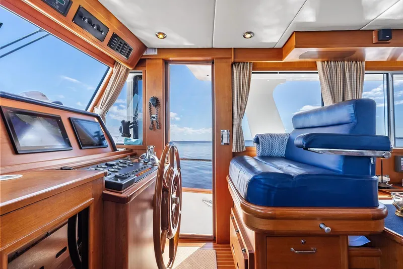 Slide: The Image of Luxurious 2006 Grand Banks Europa 47 yacht interior with wooden helm and blue seating. - 38