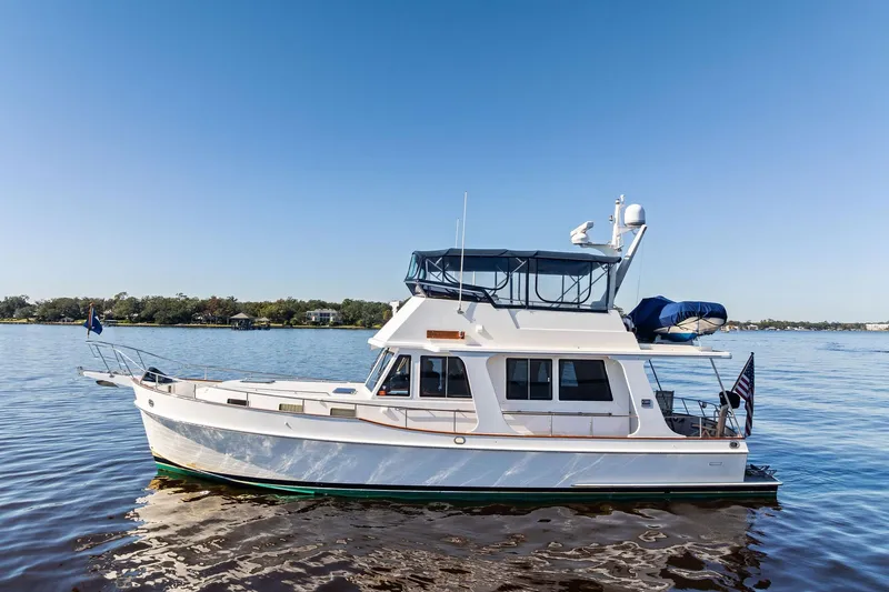 Slide: The Image of 2006 Grand Banks Europa 47 yacht on calm water under clear blue sky. - 4