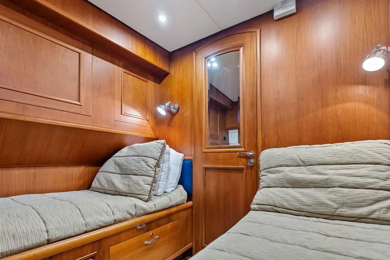 Slide: The Image of Cozy cabin interior of 2006 Grand Banks Europa 47 yacht with wooden paneling and twin beds. - 45
