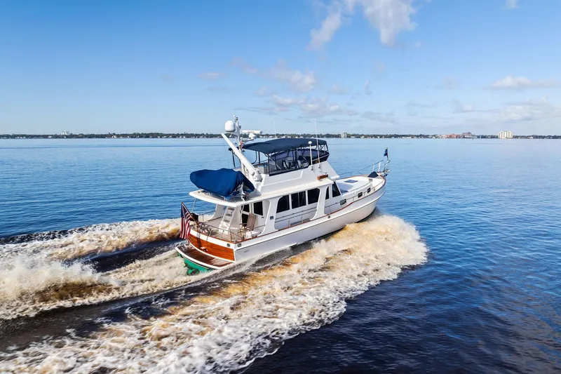 Slide: The Image of 2006 Grand Banks Europa 47 yacht cruising on open water under a clear blue sky. - 56