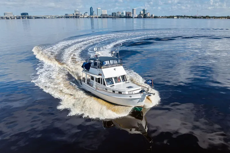 Slide: The Image of 2006 Grand Banks Europa 47 cruising on calm waters with city skyline backdrop. - 58