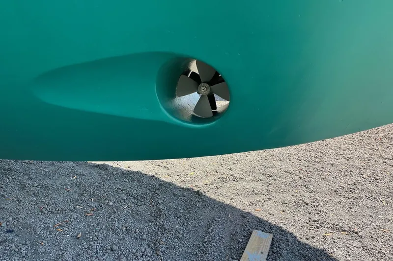 Slide: The Image of Bow thruster on 2006 Grand Banks 47 Heritage EU yacht hull, resting on gravel. - 62