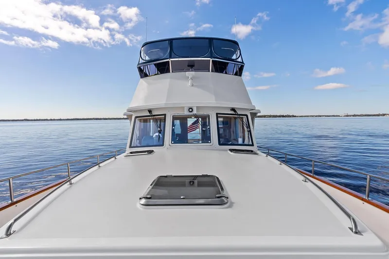 Slide: The Image of 2006 Grand Banks Europa 47 yacht on calm water under blue sky. - 9