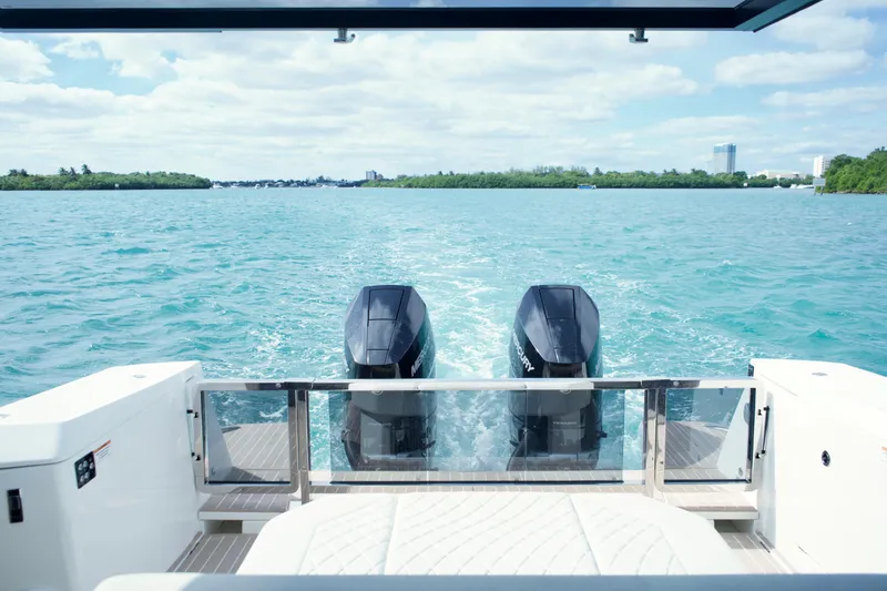 Slide: The Image of 2025 Saxdor 400 GTO boat with dual engines cruising on a clear blue lake. - 12
