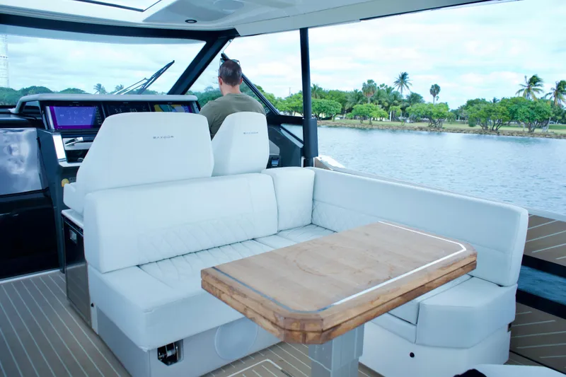 Slide: The Image of 2025 Saxdor 400 GTO interior with white seating and wooden table, overlooking serene water. - 18