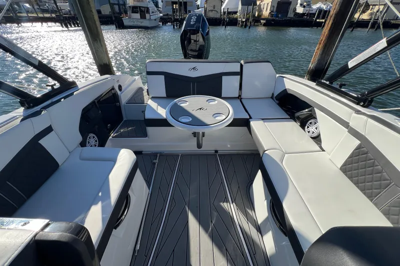 Slide: The Image of 2023 Monterey 275SS Super Sport boat interior with seating and table on water. - 11