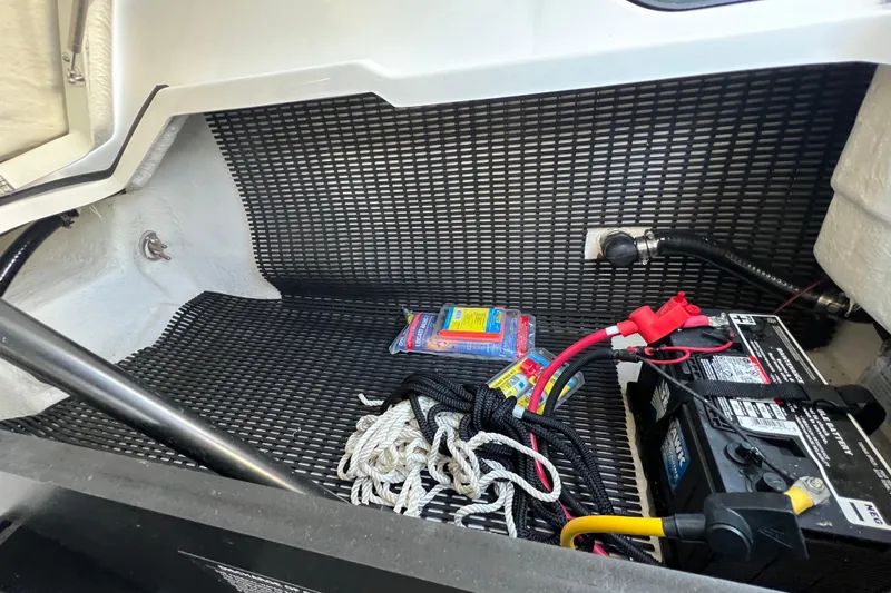 Slide: The Image of 2023 Monterey 275SS Super Sport storage area with battery, ropes, and supplies. - 32