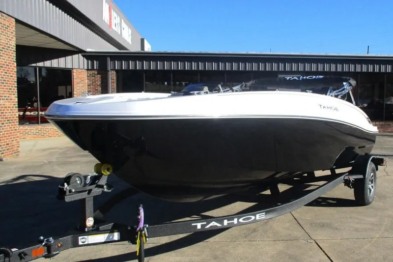 Slide: The Image of 2026 Tahoe T18 boat on trailer, parked outside a dealership. - 5