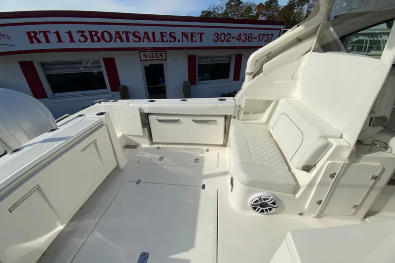 Slide: The Image of 2024 Pursuit DC 326 Dual Console boat interior with white seating and storage compartments. - 15