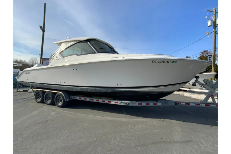 Slide: The Image of 2024 Pursuit DC 326 Dual Console boat on trailer, side view. - 2