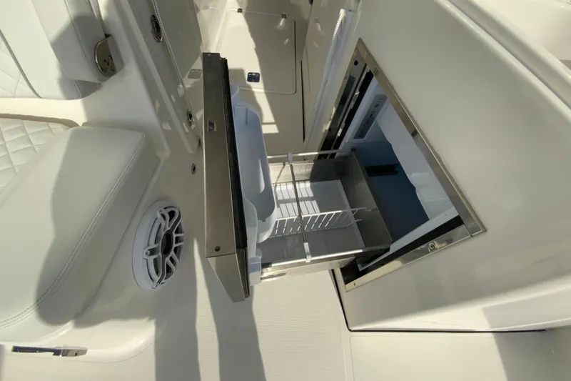 Slide: The Image of 2024 Pursuit DC 326 Dual Console boat interior with seating and kitchenette, showcasing modern design. - 20