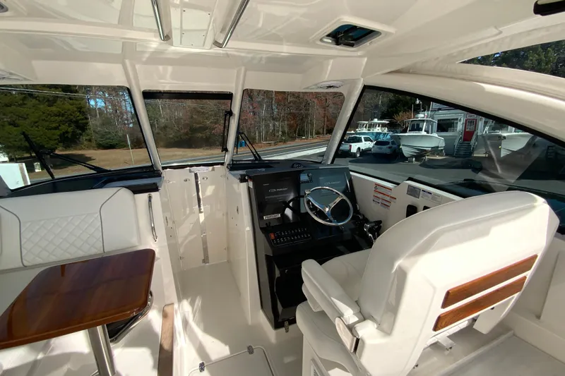 Slide: The Image of 2024 Pursuit DC 326 Dual Console interior with seating and wooden table. - 23