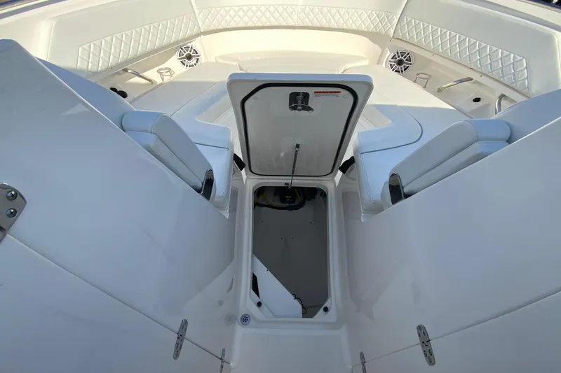 Slide: The Image of 2024 Pursuit DC 326 Dual Console interior storage compartment with wiring and equipment. - 36