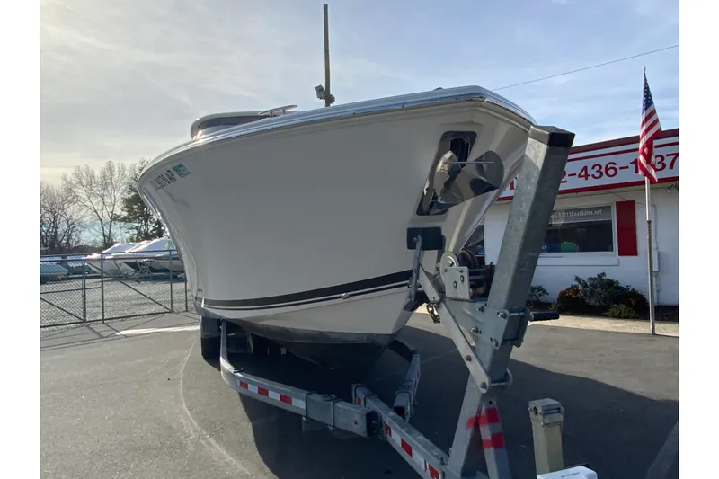 Slide: The Image of 2024 Pursuit DC 326 Dual Console boat on trailer, side view in sunlight. - 4