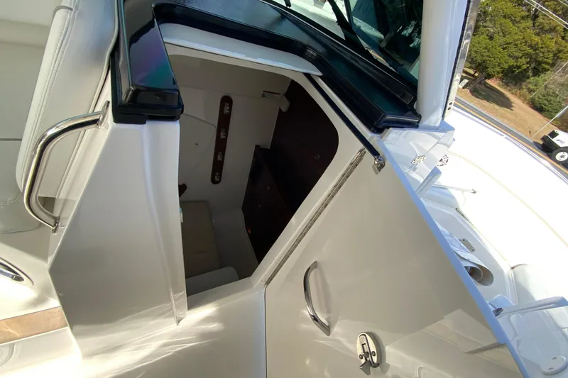 Slide: The Image of 2024 Pursuit DC 326 Dual Console cabin interior with beige seating and wooden accents. - 40