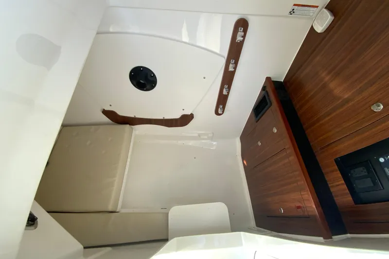 Slide: The Image of 2024 Pursuit DC 326 Dual Console interior with seating and table, showcasing luxury design. - 44