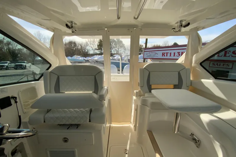 Slide: The Image of 2024 Pursuit DC 326 Dual Console storage compartment with open hatch and secure latch. - 45
