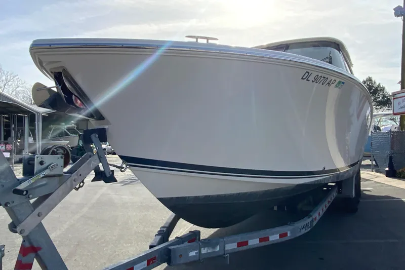 Slide: The Image of 2024 Pursuit DC 326 Dual Console boat on a trailer in a parking lot. - 5